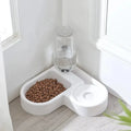 Pet food bowl with water dispenser on a light wood floor.